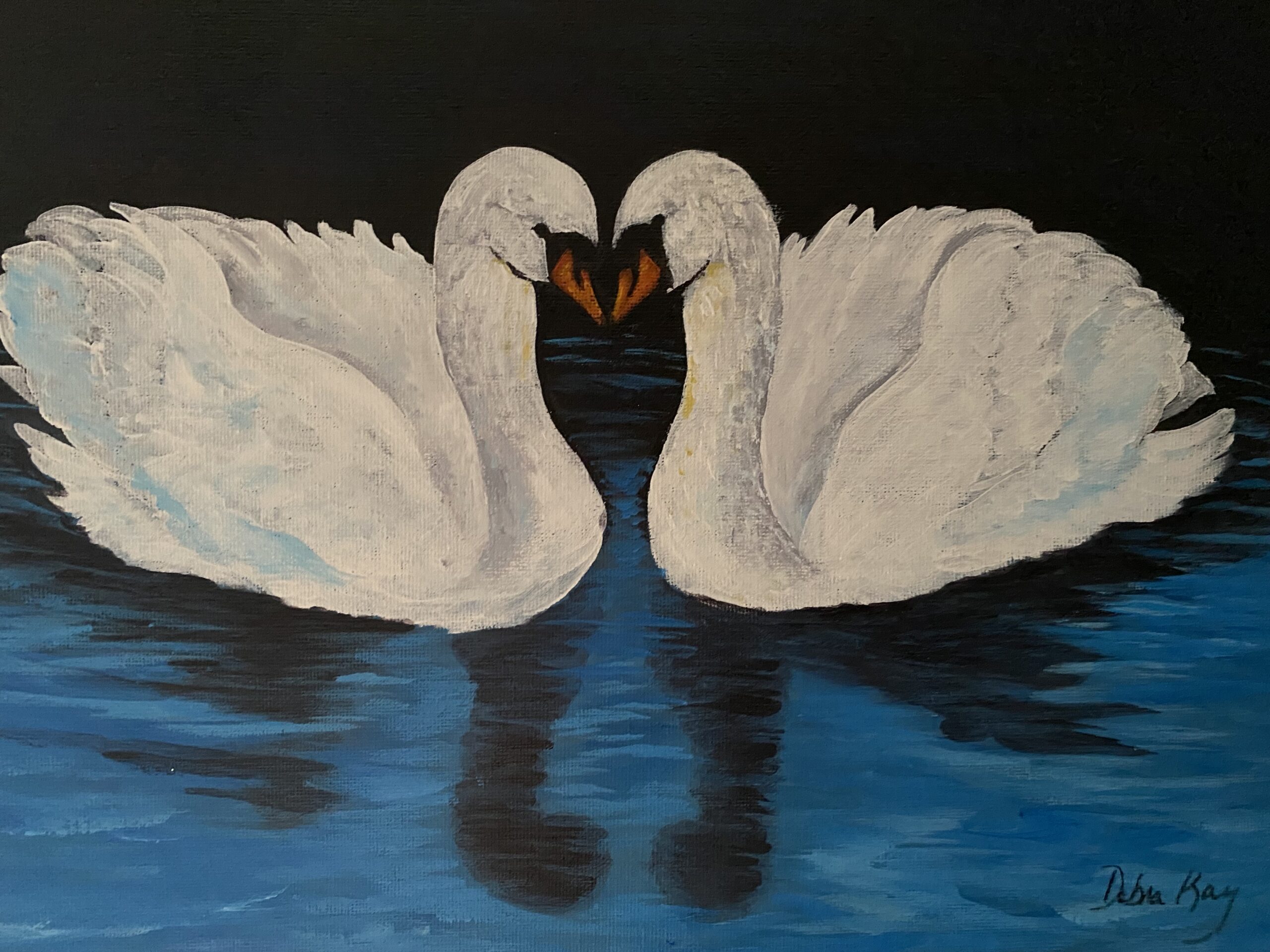 Two swans head to head on blue water