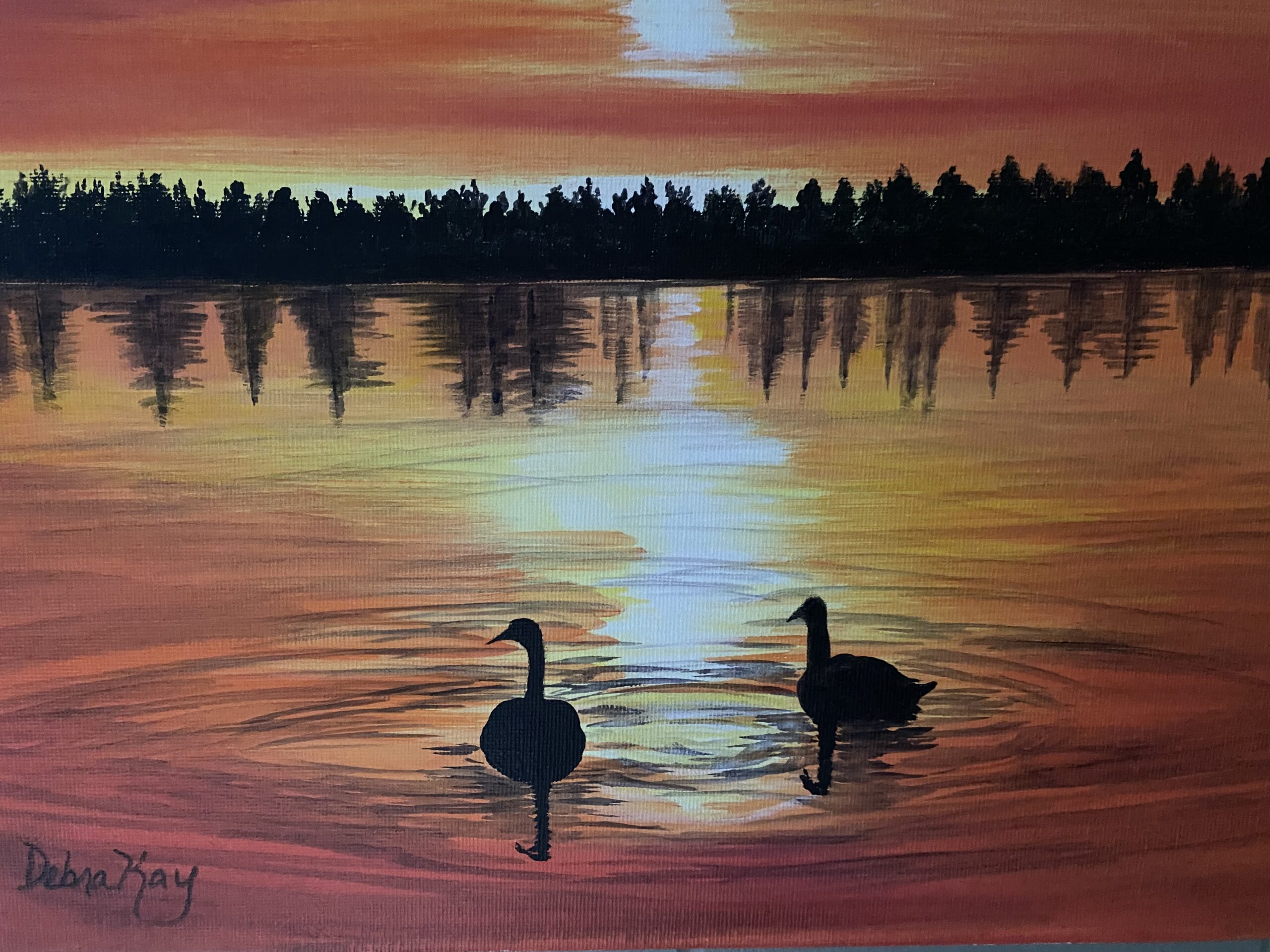 Two swans silhouettes against the sunset